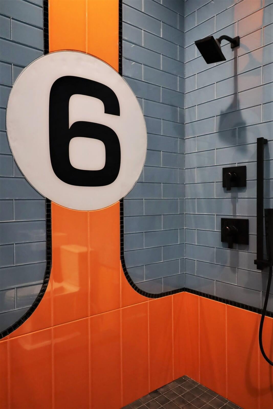 Racecar, bath, black fixture, blue tile, orange tile, custom shower